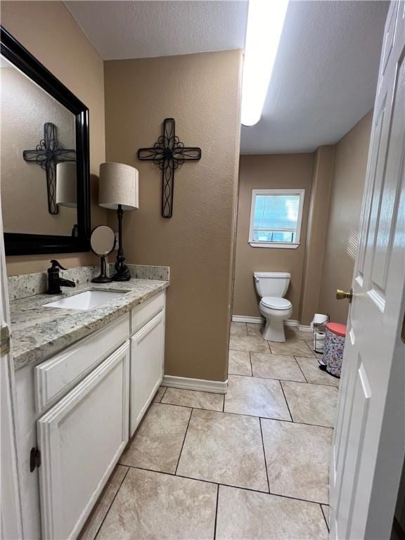 bathroom featuring tile patterned flooring, vanity, toilet, and a textured ceiling