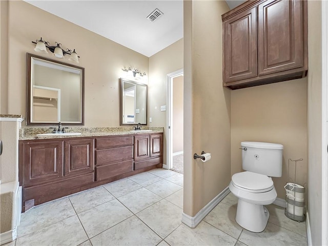 bathroom with toilet, vanity, and tile patterned floors