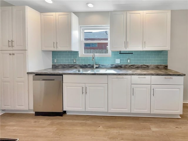 kitchen with sink, white cabinetry, backsplash, light hardwood / wood-style floors, and stainless steel dishwasher