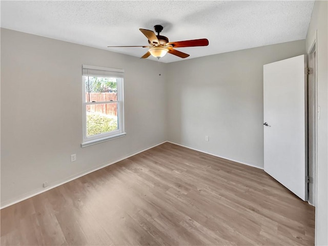 spare room featuring light hardwood / wood-style floors and a textured ceiling