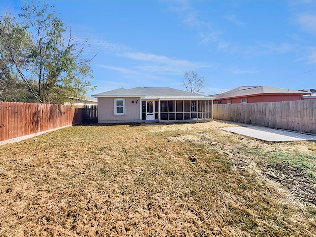 rear view of house with a yard, a patio area, and a sunroom