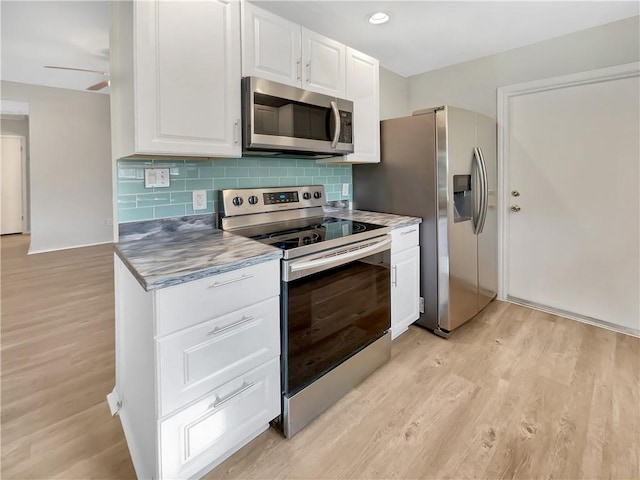 kitchen with tasteful backsplash, ceiling fan, stainless steel appliances, light hardwood / wood-style floors, and white cabinets