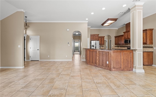 kitchen featuring stainless steel appliances, kitchen peninsula, crown molding, decorative columns, and decorative backsplash