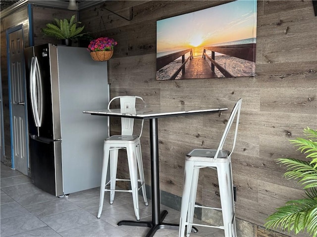 interior space with stainless steel refrigerator and light tile patterned floors