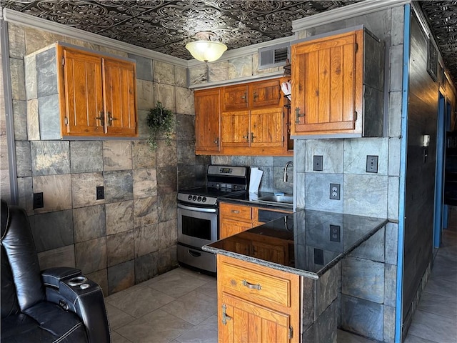 kitchen with crown molding, sink, tile walls, and stainless steel range with electric cooktop