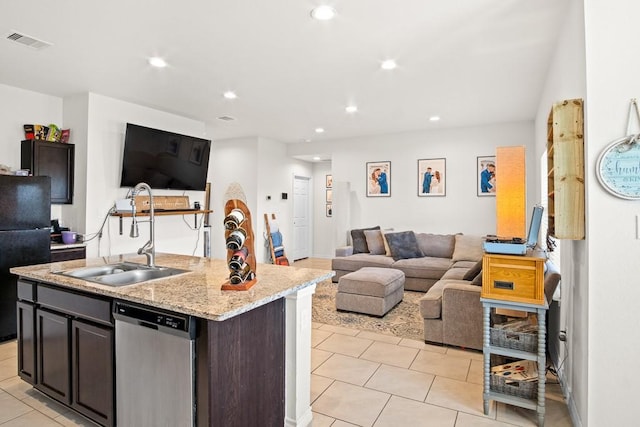 kitchen with dishwasher, dark brown cabinetry, a center island with sink, and sink