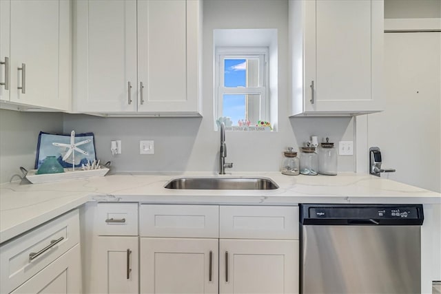 kitchen with light stone countertops, white cabinetry, sink, and dishwasher