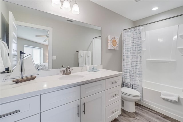 full bathroom featuring shower / bath combo with shower curtain, toilet, hardwood / wood-style flooring, vanity, and ceiling fan