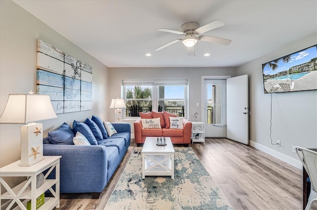 living room with wood-type flooring and ceiling fan