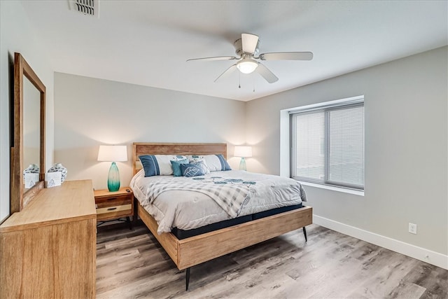 bedroom with dark hardwood / wood-style flooring and ceiling fan