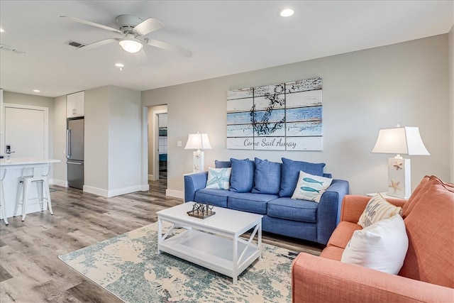 living room featuring ceiling fan and light wood-type flooring