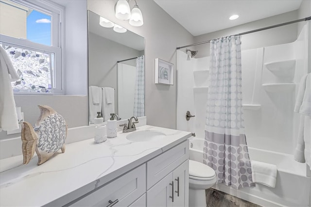 full bathroom featuring vanity, hardwood / wood-style flooring, toilet, and shower / bathtub combination with curtain