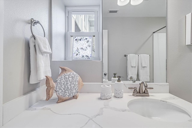 bathroom with walk in shower and vanity