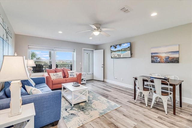 living room featuring light hardwood / wood-style floors and ceiling fan