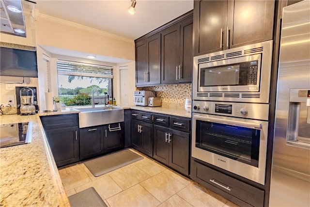 kitchen featuring light stone countertops, sink, ornamental molding, and stainless steel appliances