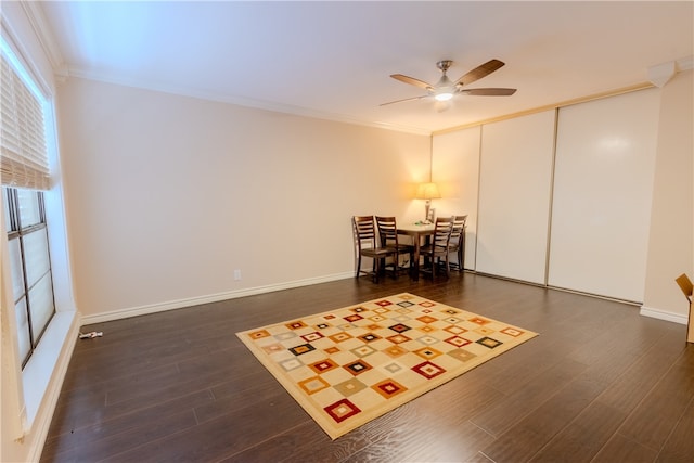 living area featuring dark hardwood / wood-style floors, crown molding, and ceiling fan