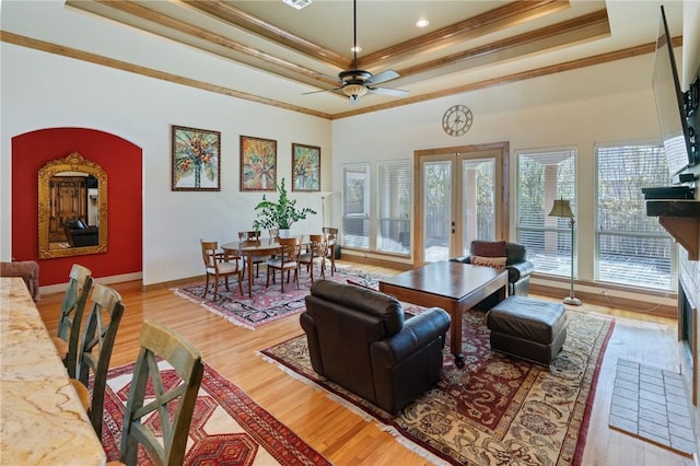 living room featuring ornamental molding, a raised ceiling, and wood finished floors