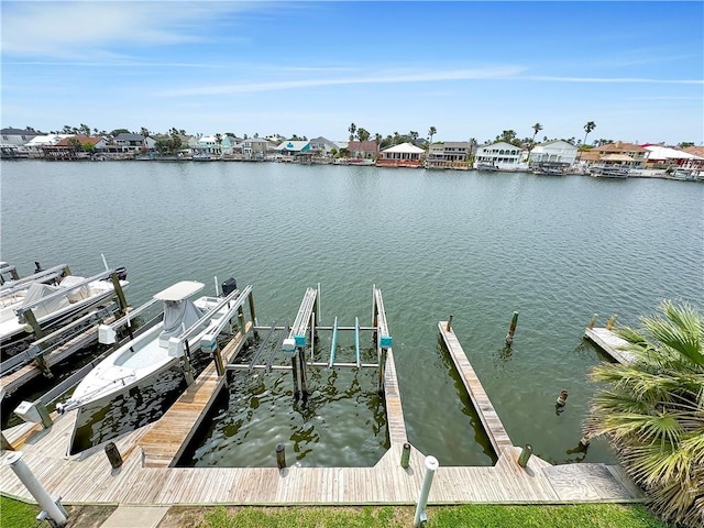 dock area with a residential view, boat lift, and a water view
