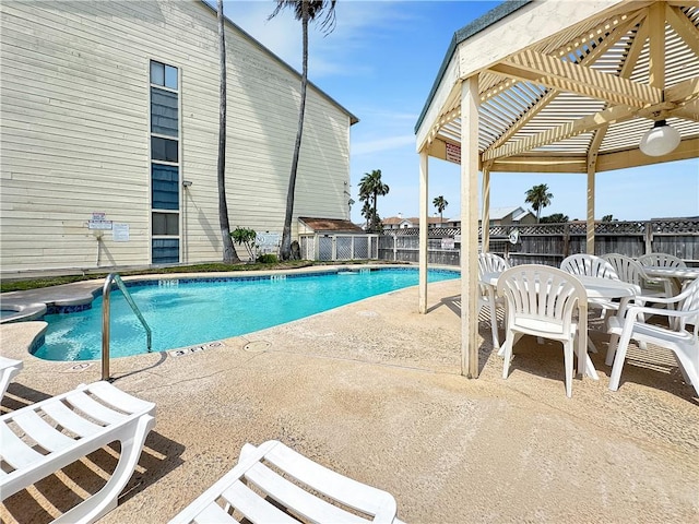 pool with a fenced backyard, a pergola, a patio area, and outdoor dining space