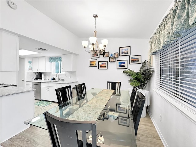 dining area featuring a notable chandelier, visible vents, and light wood-type flooring