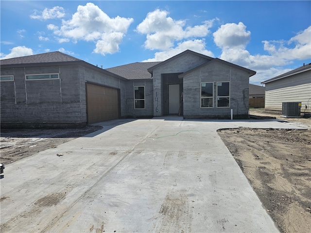 view of front of home with a garage and central AC