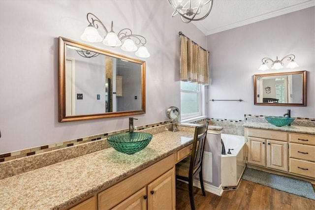 4537 Silver Hollow Dr, Corpus Christi, TX 78413 - bathroom with crown molding, two vanities, a bath, wood finished floors, and a chandelier
