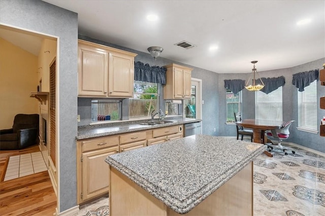 4537 Silver Hollow Dr, Corpus Christi, TX 78413 - kitchen with light brown cabinets, stainless steel dishwasher, light wood-style flooring, a kitchen island, and hanging light fixtures