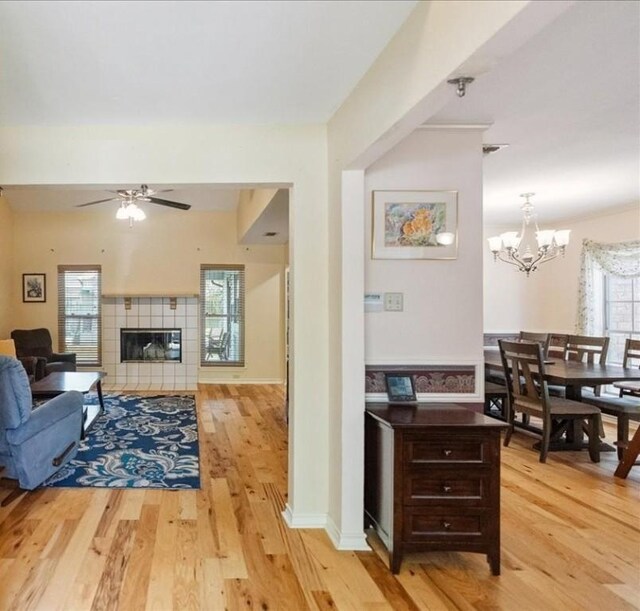 4537 Silver Hollow Dr, Corpus Christi, TX 78413 - living room with light wood finished floors, a chandelier, a ceiling fan, and a tile fireplace