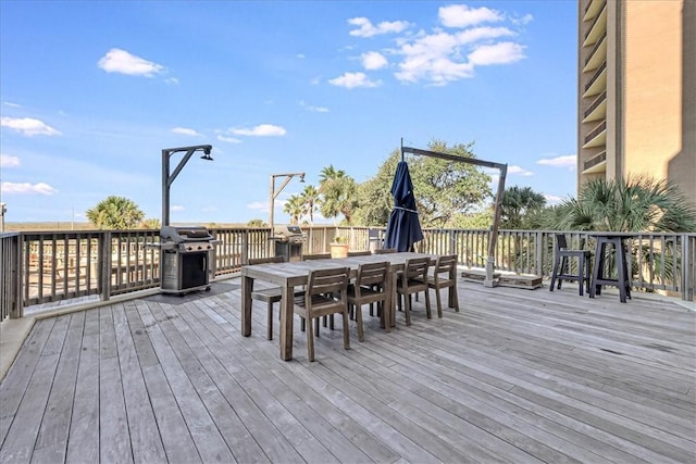 wooden deck with outdoor dining area and area for grilling