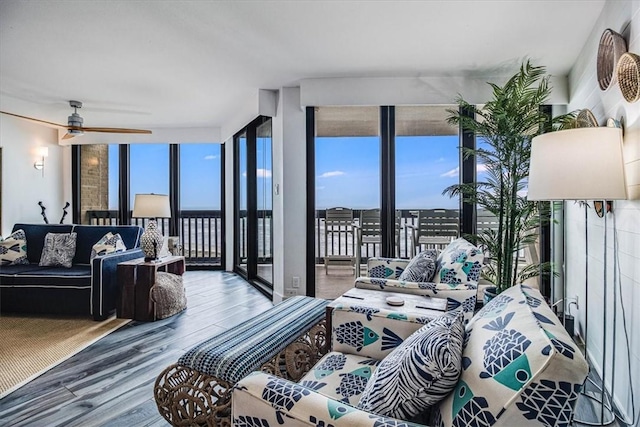 bedroom with access to outside, a view of city, expansive windows, and wood finished floors