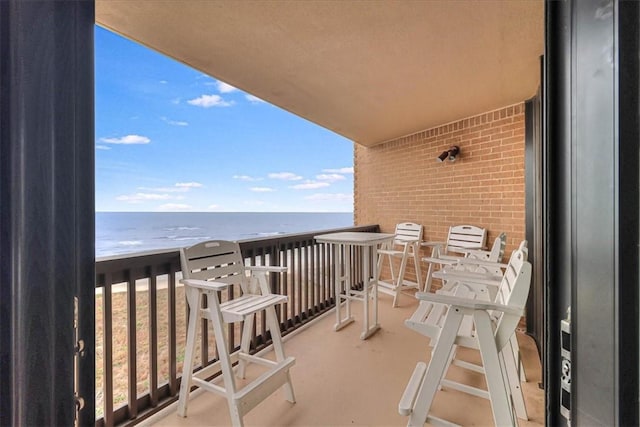 balcony featuring a water view and a beach view