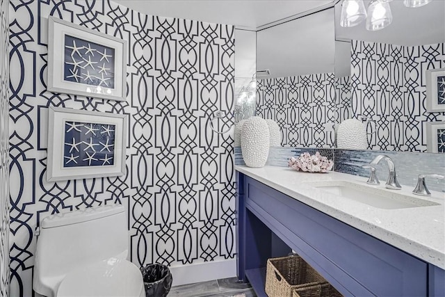 bathroom with toilet, tile walls, backsplash, and vanity