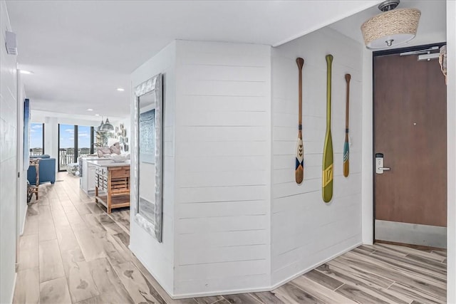 hall with light wood-style floors and baseboards