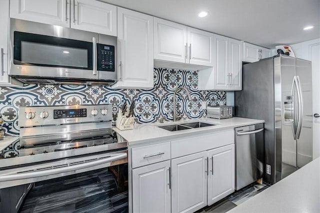 kitchen with stainless steel appliances, white cabinets, light countertops, and a sink