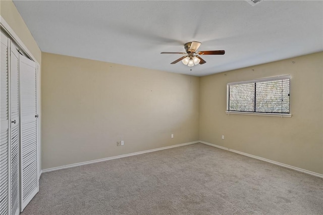 unfurnished bedroom featuring ceiling fan, light colored carpet, and a closet