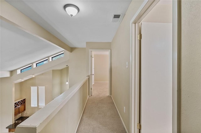 hall featuring light carpet and lofted ceiling with beams