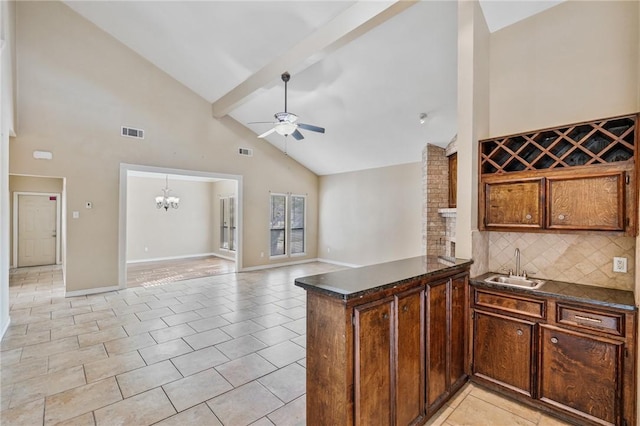 kitchen featuring sink, tasteful backsplash, high vaulted ceiling, kitchen peninsula, and ceiling fan with notable chandelier