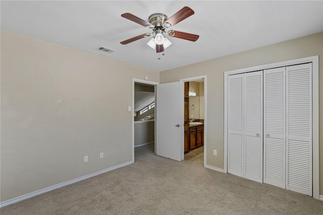 unfurnished bedroom featuring connected bathroom, ceiling fan, a closet, and light colored carpet