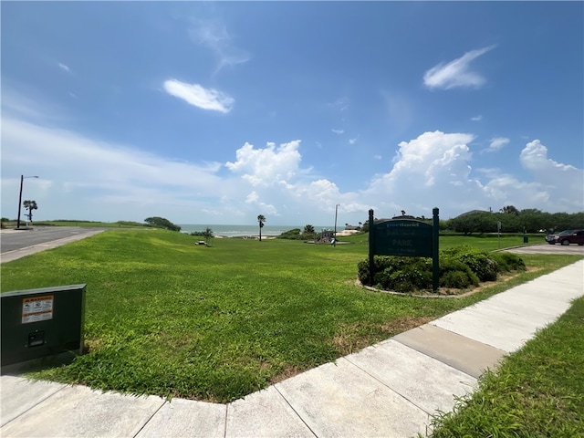 surrounding community featuring a lawn and a water view