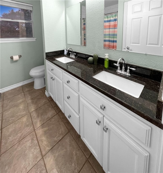 bathroom featuring toilet, vanity, and tile patterned floors