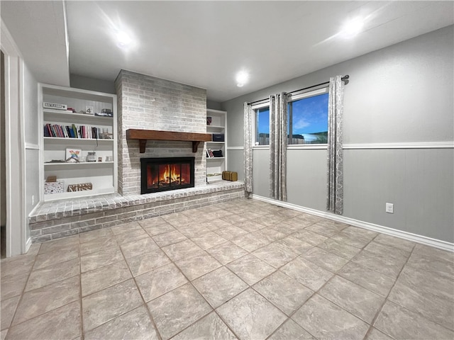 unfurnished living room with built in shelves, a brick fireplace, and tile patterned floors