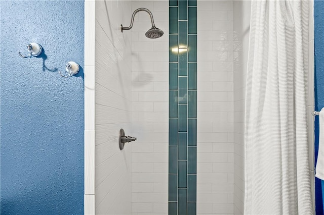 room details featuring a stall shower and a textured wall