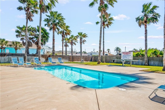 community pool with a patio and a fenced backyard