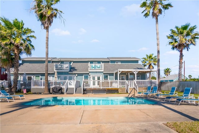 view of swimming pool with a patio, a wooden deck, a fenced in pool, and fence