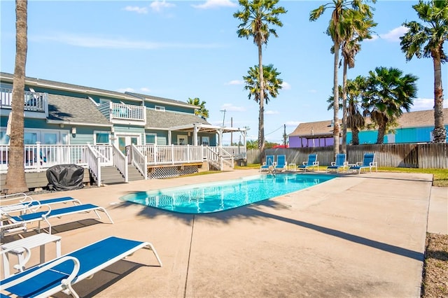 view of pool with a patio area, fence, a fenced in pool, and a wooden deck