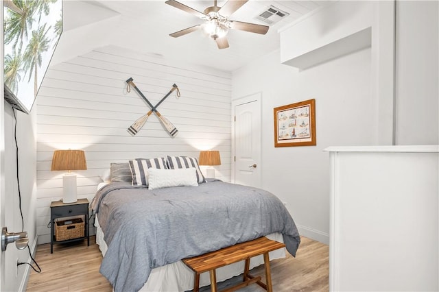 bedroom featuring light wood finished floors, visible vents, and a ceiling fan