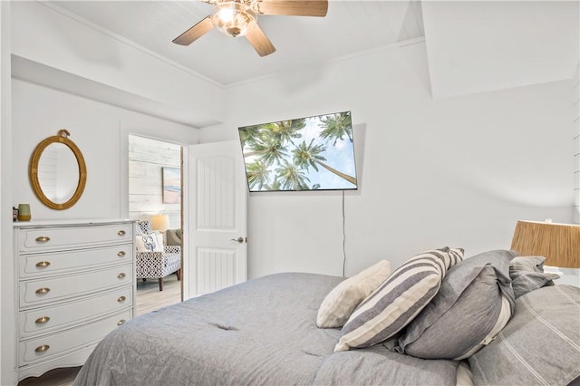 bedroom with multiple windows, wood finished floors, a ceiling fan, and crown molding