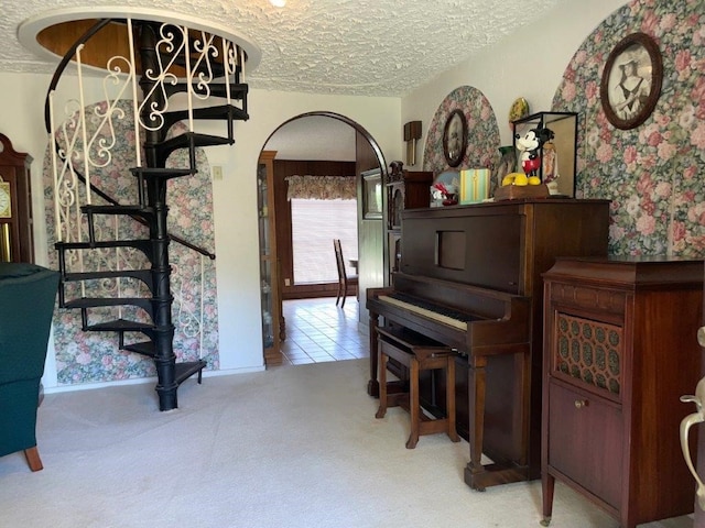 miscellaneous room with a textured ceiling and light carpet