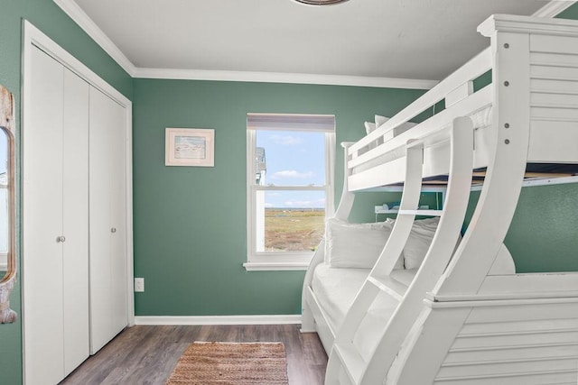 bedroom featuring dark wood-type flooring, a closet, and ornamental molding