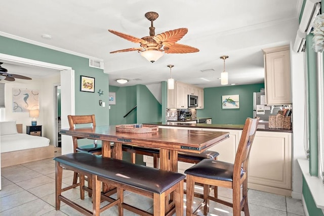 dining room featuring ceiling fan, light tile patterned flooring, and crown molding